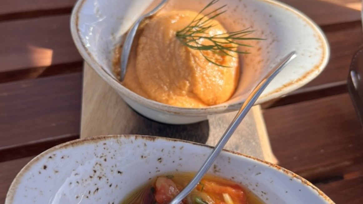 Mediterranean dips and dishes on a sunlit wooden table